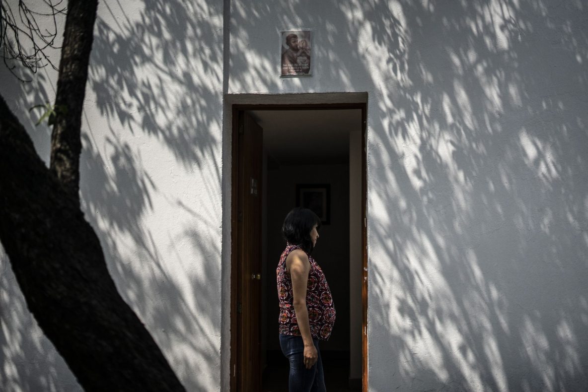 A woman stands by a door